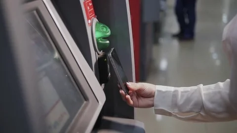 Smiling young woman withdrawing money from ATM using phone contactless pay Stock Footage