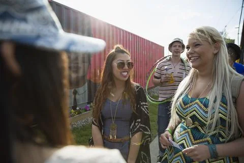 Smiling young women waiting in queue at summer music festival Stock Photos