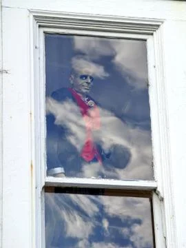 Smiling zombie behind a window Stock Photos