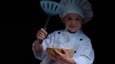 Smily boy wearing chefs suit with bowl of french fries on the black background Stock Footage 92559994