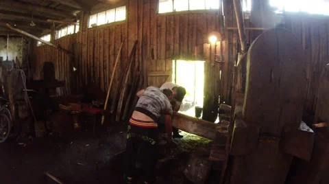 Smith and Apprentice Blacksmith Working on a Water-Powered Machine in the Stock Footage 59762910