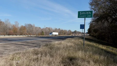 Smith County Sign Static Wide with Passing Cars Right Frame Stock Footage 99413286