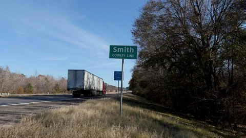 Smith Cty Sign Static Wide Center Frame with Passing Cars Stock Footage 99413220