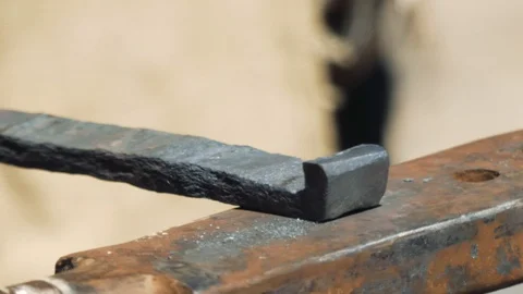 Smith forming red hot iron in hook on anvil. Blacksmith in forge beats hammer Видео 110836493