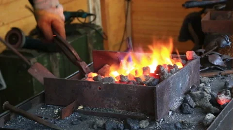 Smith kindles coals in a smiths hearth Stock Footage 45942010