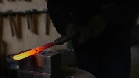 The smith processes the hot iron on the machine Stock Footage 78902509