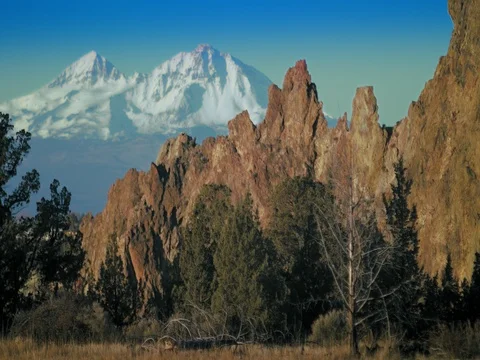 Smith Rock wall against snow covered mountains  Stock Footage 83229952