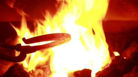 The smith in a smithy forges a horseshoe Stock Footage 61502287