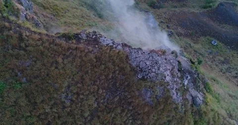 Smoke from active volcano coming out of a rocky ground Video stock 114585747