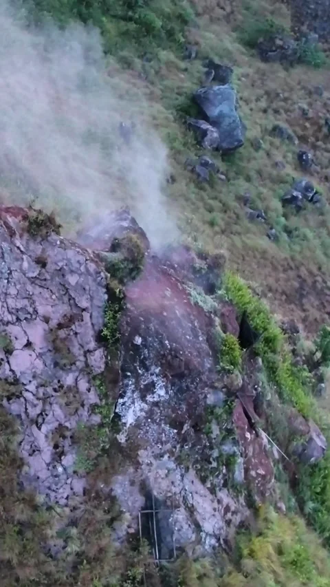 Smoke from active volcano coming out of a rocky ground Stock Footage 230290915