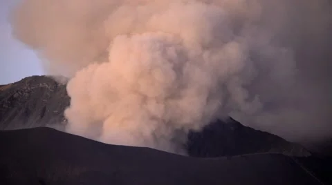 Smoke and ash erupting from Mount Bromo volcano in barren terrain Java Indonesia Stock Footage 67390491