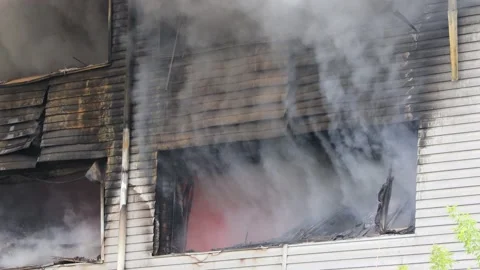Smoke and fire from a window in a warehouse during a fire Stock Footage 204799666