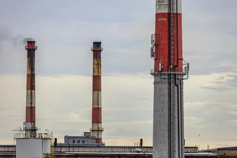 Smoke and steam released from the old factory chimney Stock Photos
