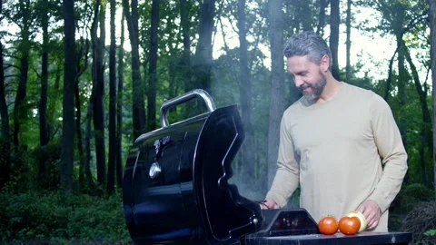 Smoke from barbeque with grilled beef. Man relaxing on picnic barbeque by nature Stock Footage 346828151