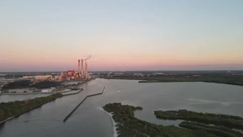 Smoke billowing off a waterfront coal powerplant Stock Footage