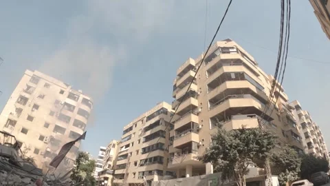 Smoke billows from a building that completely collapsed in the southern subu Video stock 289846529