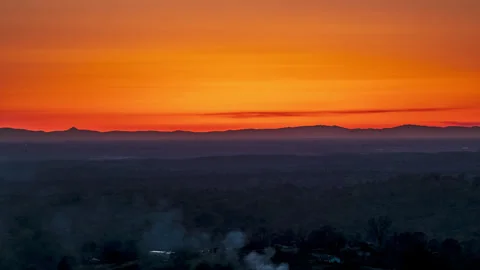 Smoke Billows in Foreground as Sun Sets Behind Coastal Range Stock Footage 282377827