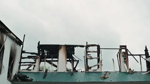 Smoke billows from the remains of a burned structure. Firefighters are present, Stock-Footage 339095951