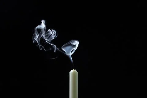 Smoke from a candle on a black background. An extinguished candle on a dark back Stock Photos