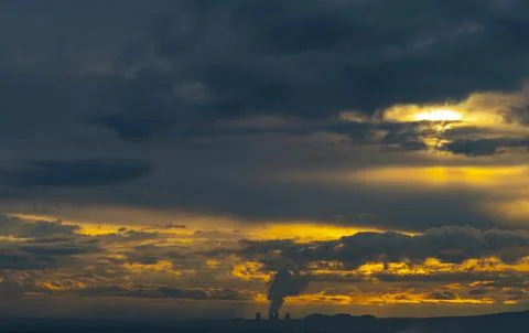 Smoke from the chimney of a nuclear power plant at sunset Stock Photos