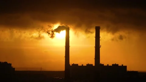 Smoke from chimney. Sun and low clouds behind. Pipes in silhouette. 스톡 동영상 236172018