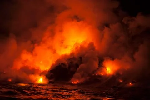 Smoke clouds from lava flow impacting sea at night, Kilauea volcano, Hawaii Stock Photos