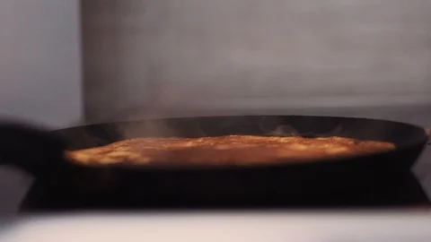 Smoke comes from the finished side of the pancake lying in the pan. Stock Footage 112017826