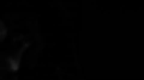 Smoke coming from the left side, slowly swirling in space on black background Stock Footage 51470949
