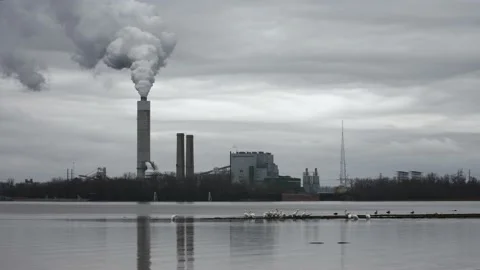 Smoke coming out of a smoke stack at a coal-fired power plant across the Stock Footage 230218329