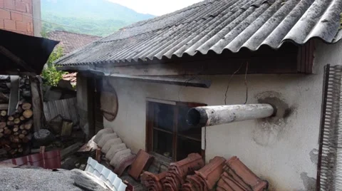 Smoke coming from a pipe in the wall of an old house Stock Footage 49787001