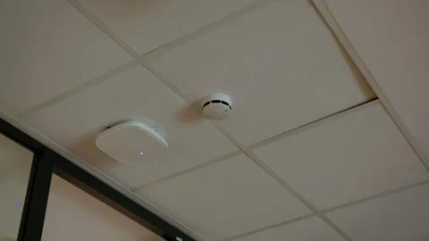 Smoke detector and wifi access point on white suspended ceiling indoors Stock Footage 337777243
