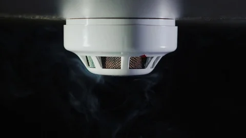 Smoke detector on a black background. There are trickles of smoke. The sensor is Stock Footage 84884827
