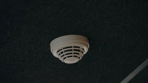 Smoke Detector on a Textured Black Ceiling: Home Safety and Fire Prevention Stock Footage 315771196