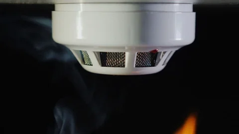 The smoke detector is triggered by a fire. Smoke and flames are visible Stock Footage 84883639