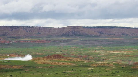 Smoke drifting over badlands plain at military firing range Stock Footage 337800490