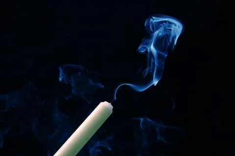 Smoke from an extinguished candle on a dark background. The concept of spir.. Stock Photos