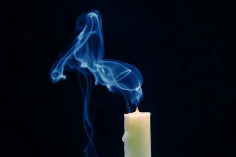 Smoke from an extinguished candle on a dark background. The concept of spir.. Stock Photos