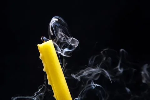 Smoke from an extinguished candle on a dark background. The concept of spir.. Stock Photos