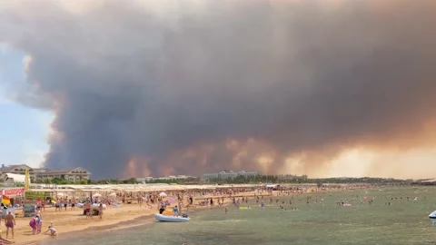 Smoke from forest fires rising over a beach in Antalya, Manavgat resort town of Stock Footage 158937595