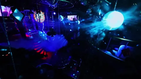 Smoke goes by dancing area in White Bear striptease club with colorful Stock Footage 276374377