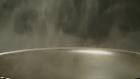 Smoke on a gray background close-up. The smoke soaring up. Steam from the pan Stock Footage 257591642