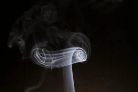 Smoke on a gray background in the form of a curl Stock Photos