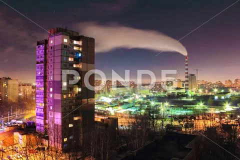 The smoke from the industrial pipe in the city at night Stock Photos
