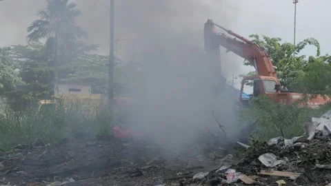 Smoke, man and burned plastic garbage in waste landfill Stock Footage 132117766