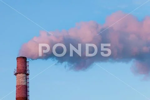 Smoke from the old pipe CHP a blue sky background at sunset. Ambient air po.. Stock Photos