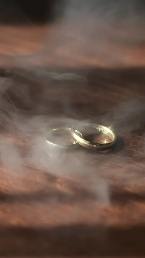 Smoke over wedding rings lying on a wooden table. Slow motion 120 fps. Stock Footage 291978802