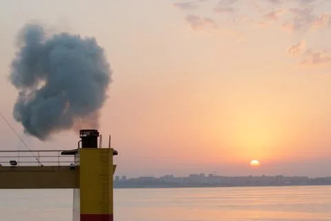 Smoke from the pipe of the ship when the main engine is started at the anchor Stock Photos