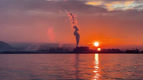Smoke Pollution at sunset by the sea, Harmful fumes coming from factory chimney Stock Footage 284035773