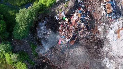 Smoke rises from burning trash piles Stock Footage 339808033