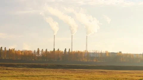 Smoke rises over autumn fields in a serene industrial landscape Vidéo 295284942